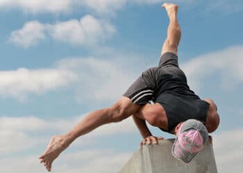 Athlete performing Flying Split arm balance (Eka Pada Koundinyasana II) demonstrating core strength, balance, and full-body control