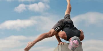 Athlete performing Flying Split arm balance (Eka Pada Koundinyasana II) demonstrating core strength, balance, and full-body control