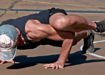 Athlete performing a push-up variation with knee on upper arm to activate the psoas muscle and core connection.