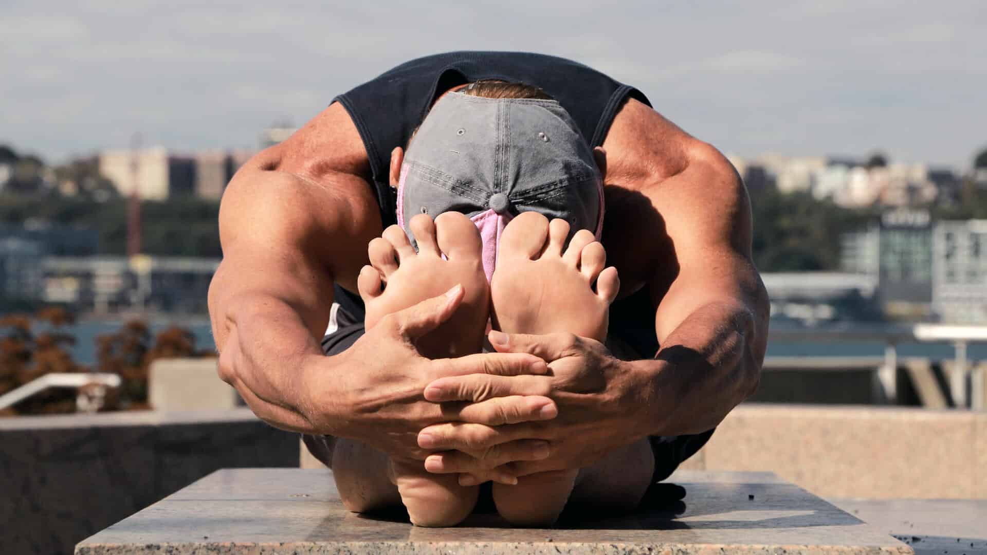 Athlete performing a seated forward fold to stretch the hamstrings and release the lower back.
